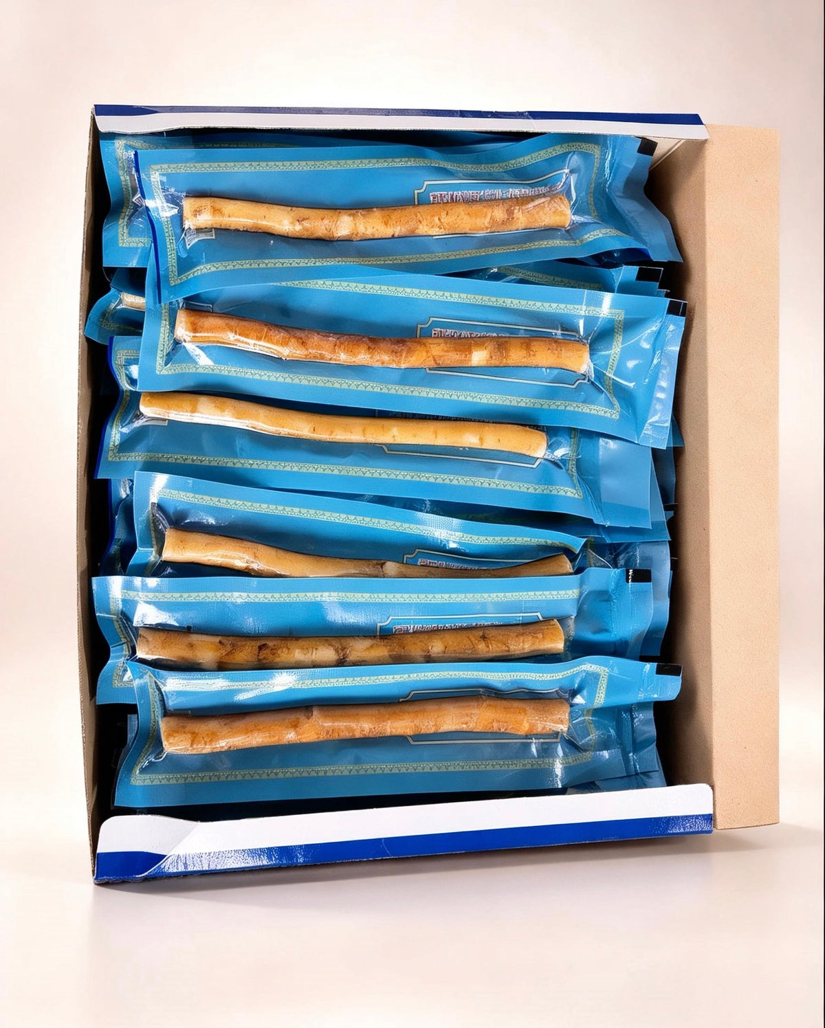 Open box of Sewak Al-Emaan natural Peelu Miswak containing individually wrapped 6-inch sticks in blue protective packaging.