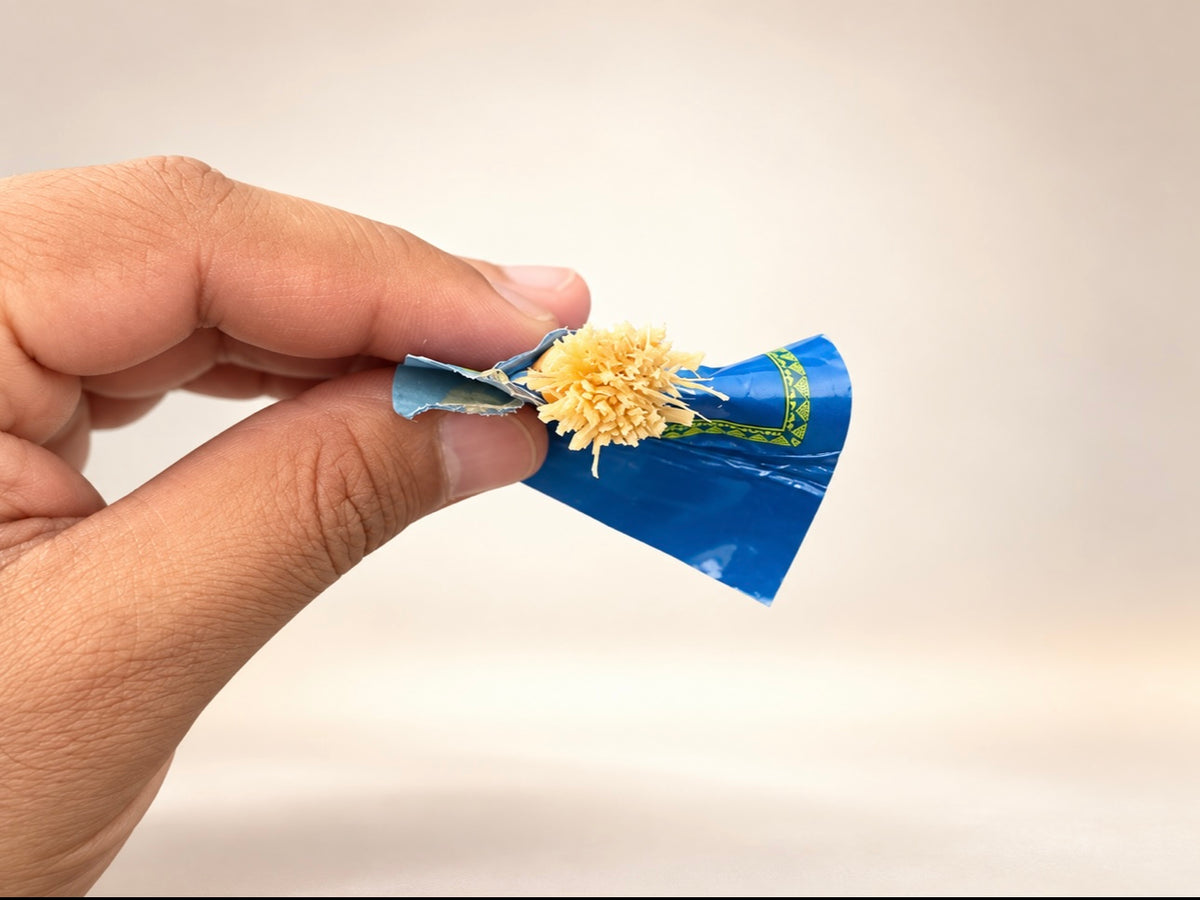 Close-up of a natural Peelu Miswak stick held by hand, showing the softened brush-like fibres used for traditional teeth cleaning.